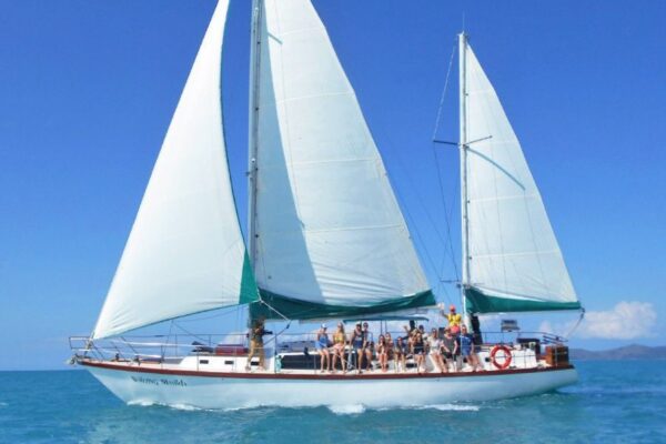 Waltzing Matilda under full sail with guests on deck in the Whitsundays