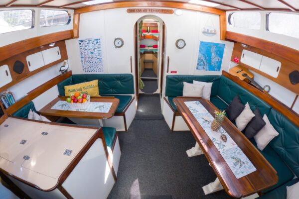 Saloon below deck on Waltzing Matilda with seating and dining tables